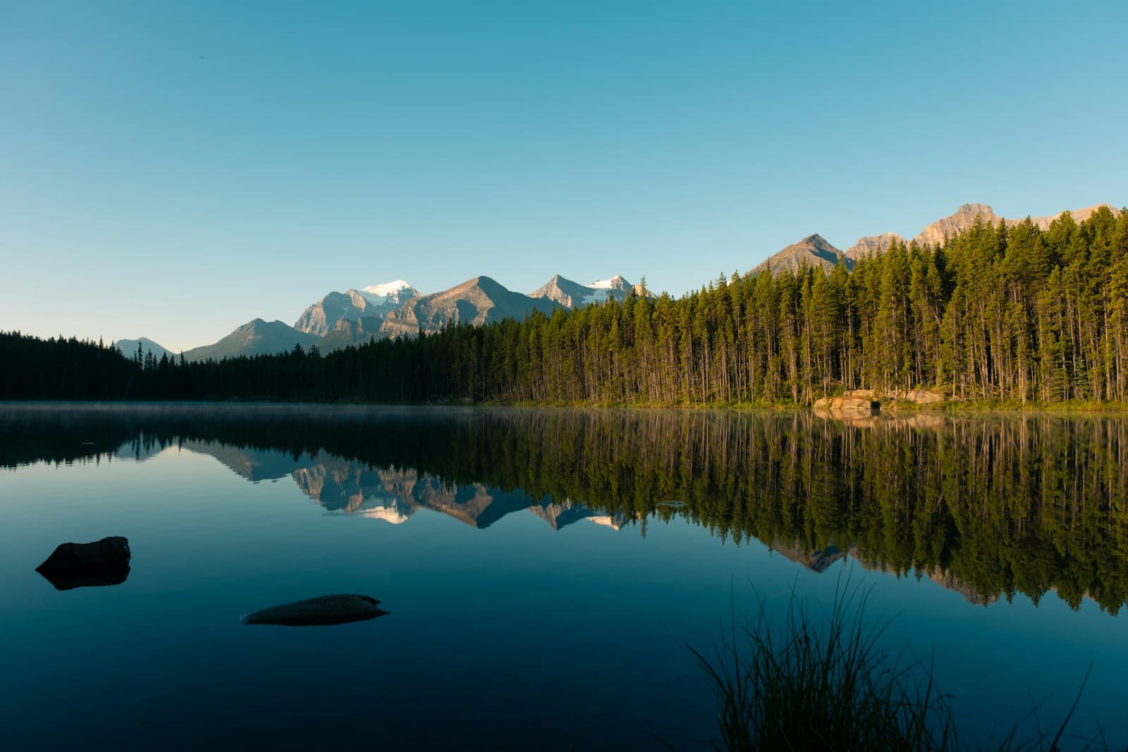 Calm lake and mountain reflection at sunrise
